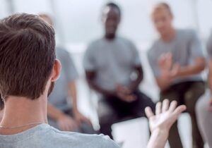 a man talks during his group therapy session in his men's rehab program