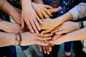 A group of people holding hands, symbolizing the role of family in addiction recovery